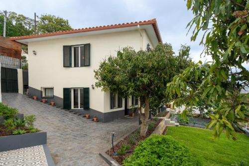 a white house with black windows and a courtyard at Casa Imaculado Coração by An Island Apart in Funchal