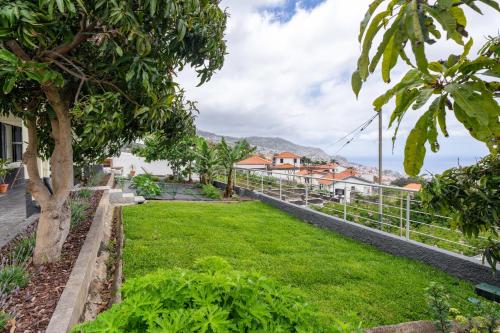 a garden with green grass and a fence at Casa Imaculado Coração by An Island Apart in Funchal