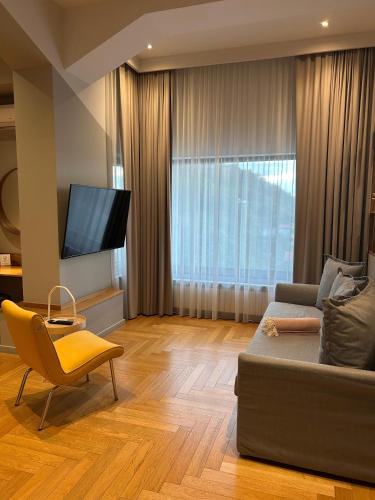 a living room with a couch and a television at Atlas Aparthotel in Piatra Neamţ