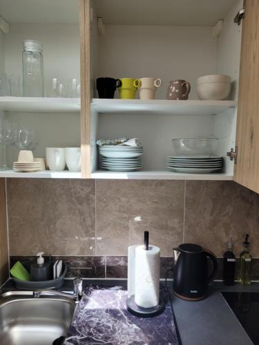 a kitchen counter with a sink and a roll of paper towels at Chez LouLou, cocon paisible 