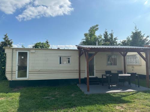 a house with a table and a gazebo at Autocamp Free Star - Mobilheimy in Strachotín