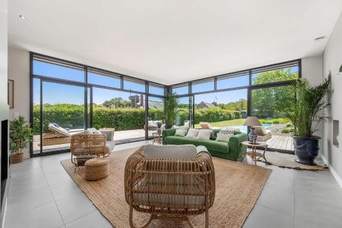 a living room with a green couch and chairs at Lavalliere - Villa de luxe avec piscine - 4 suites in Plouër-sur-Rance