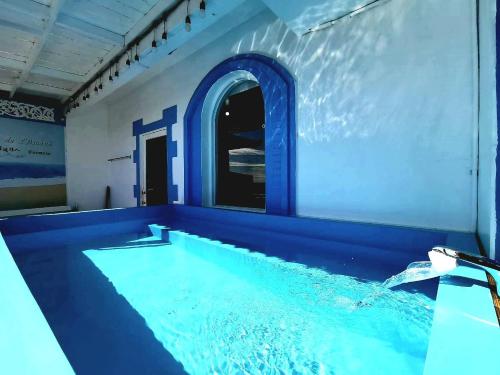 a swimming pool in a house with a blue ceiling at 燈塔情人海景民宿 in Eluan