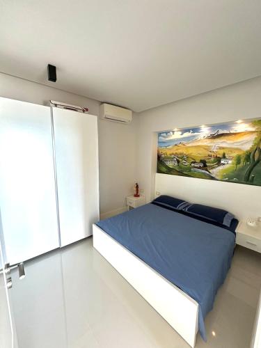 Seaside Serenity في Polisi i Vogël: غرفة نوم بها سرير ولوحة معلقة على الحائط