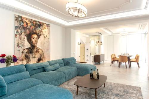 a living room with a blue couch and a painting at S2 House for 12p swimming pool AC BBQ 10mins from Sea in Nice