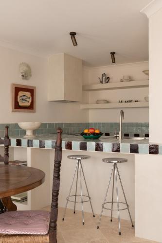 a kitchen with a sink and a counter with stools at Spacious, ocean-front, pied-à-terre with stunning views &opposite cafes in Perth