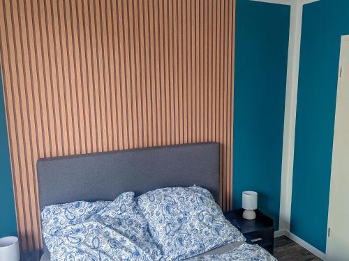 a bedroom with a bed and a striped wall at Ferienhaus Sande in Schwerin