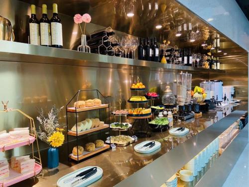 a buffet line with various pastries and bottles of wine at Insio Hotel in Shenzhen