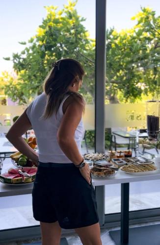 a woman standing in front of a table of food at Sunrise Apart-Hotel in Ulcinj