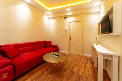 a living room with a red couch and a table at Ayasofya Hotel - Special Class in Istanbul