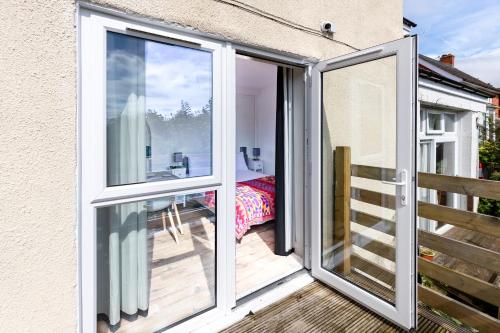 a sliding glass door to a balcony with a bedroom at Glastonbury- Tor View- Studio in Glastonbury