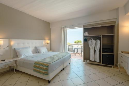 a bedroom with a large bed and a balcony at Dore Boutique Hotel in Agia Marina Nea Kydonias