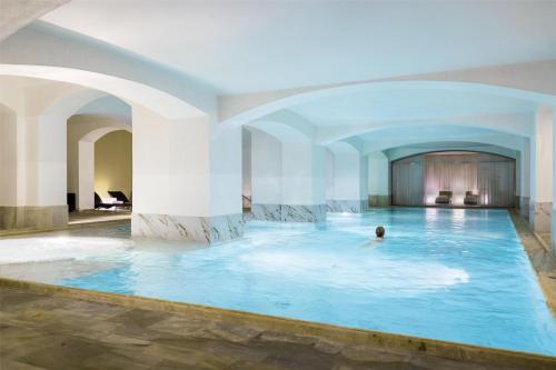 a man swimming in a pool in a hotel room at NH Collection Prague Carlo IV in Prague