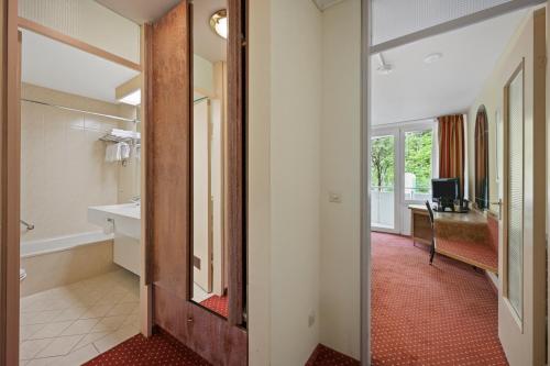 a hallway with a bathroom with a sink and a mirror at Schwarzwaldapartment Nr 17 30qm Doppelbettbett Rustikal in Altensteig