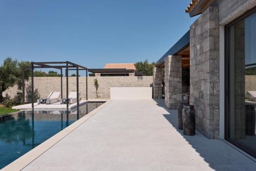 a walkway leading to a swimming pool next to a house at Noero Villas Lefkada in Lefkada Town