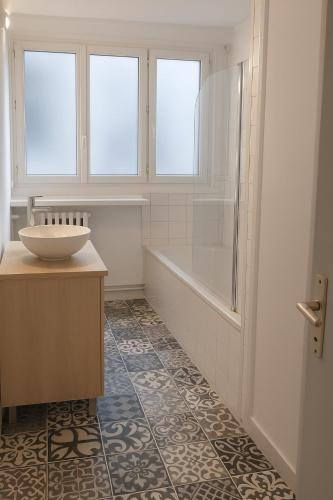 une salle de bain avec un lavabo et une baignoire et un lavabo dans l'établissement La boulange, appartement familial ou entreprise Ménage et linge inclus, à Rouen