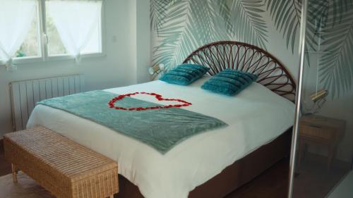 une chambre avec un lit avec des oreillers bleus dans l'établissement Le Spa SAJ, à Émiéville