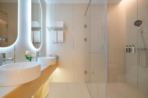 a bathroom with a sink and a shower at Layflat Hotel in Shenzhen