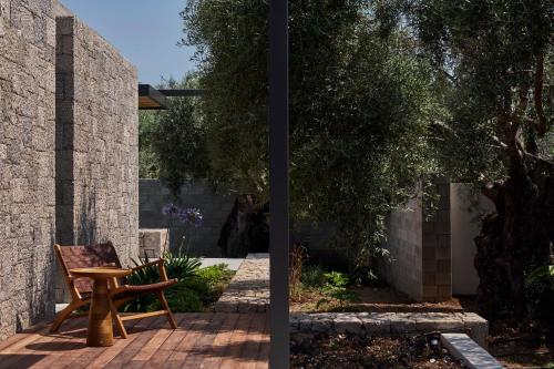 a wooden bench sitting on a patio next to a brick wall at Noero Villas Lefkada in Lefkada Town