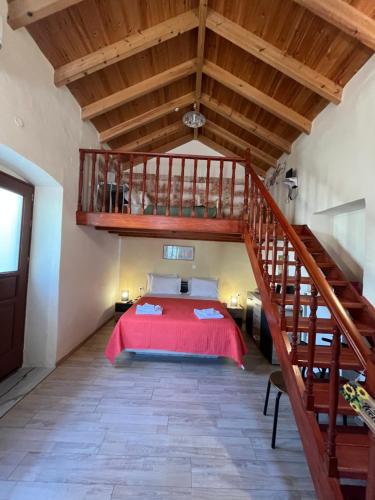 a bedroom with a red bed and a staircase at Foteini’s House in Symi