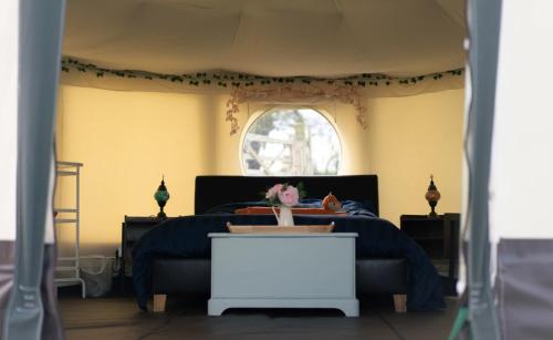 a bedroom with a bed and a window at Little River Glamping in Ballymoney
