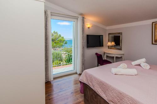 a hotel room with a bed and a large window at Rustical Vila VERDE with traditional Tavern & Pool in Jasenice