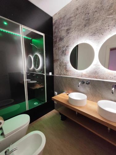 a bathroom with two sinks and two mirrors at Alma Suites - Il Nido d'Amore in Livorno