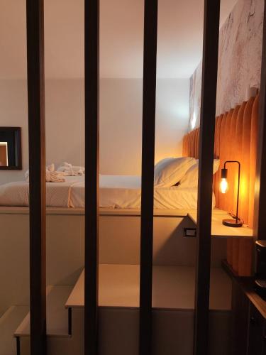 a bed is seen through a window in a room at Alma Suites - Il Nido d'Amore in Livorno