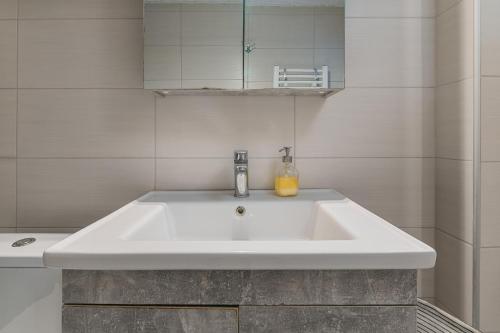a white sink in a bathroom with a mirror at The Little Loft in Pefkochori