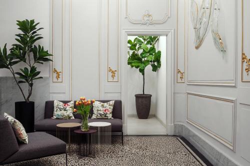 a living room with two couches and a table with flowers at R16 Residences Prague in Prague