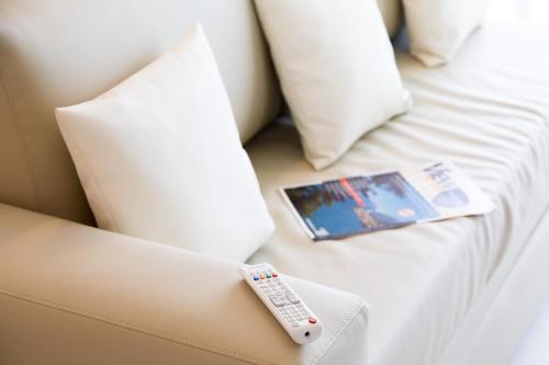 a remote control sitting on top of a white bed at Hotel Vega in Malcesine