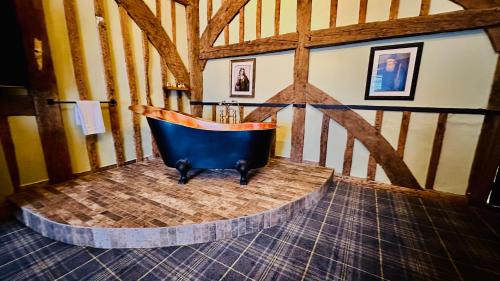 a bathroom with a blue tub in a room at The Ostrich Inn Colnbrook London Heathrow in Slough
