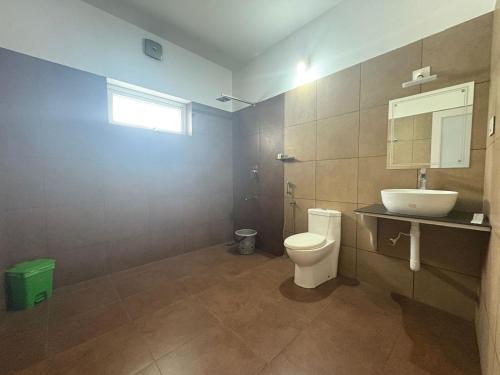 a bathroom with a toilet and a sink at The Golden Oak A Classic Villas in Vythiri