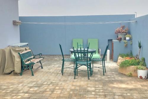 un patio con tavolo e sedie e un muro blu di Sabiduría a Hentiesbaai