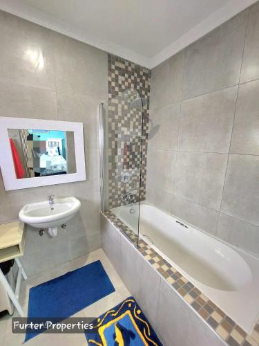 un bagno con un lavandino, una vasca da bagno e un lavandino di Sabiduría a Hentiesbaai