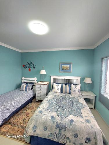 una camera da letto con un letto grande e pareti blu di Sabiduría a Hentiesbaai
