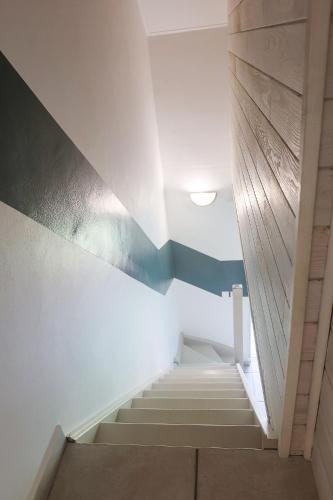 a staircase in a room with white and blue walls at KETYA Duplex Mabouya OU Studio Hamac in Le Gosier