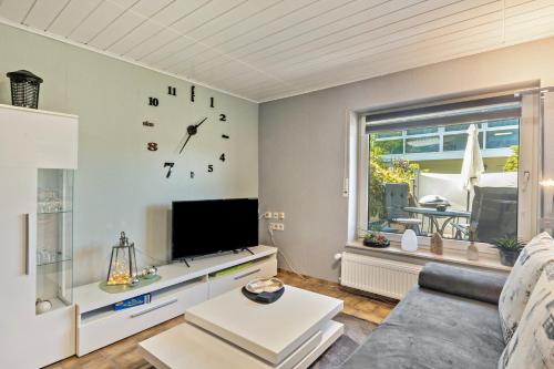 a living room with a couch and a clock on the wall at Fewo Oase Ruhrtalblick in Bestwig