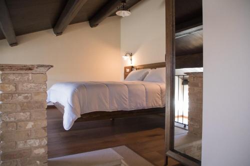 ein Schlafzimmer mit einem Bett und einer Ziegelwand in der Unterkunft Casale Madonna Grande Wine Resort in Campomarino