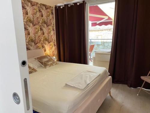 a bed in a room with a window at Apartments Ylona in Primošten