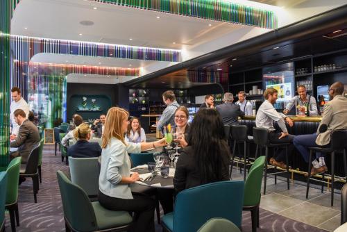 a group of people sitting at tables in a restaurant at Mercure Paris Boulogne in Boulogne-Billancourt