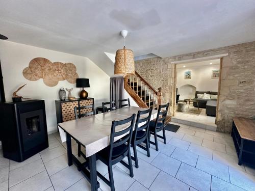une salle à manger avec une table et des chaises en bois dans l'établissement Halte Lutine - Maison chaleureuse en pierres, à Luc-sur-Mer