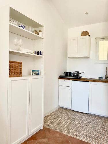 une cuisine avec des placards blancs et un comptoir dans l'établissement Studio avec terrasse, parking et clim à 10 min à pied du vieux port, à La Ciotat