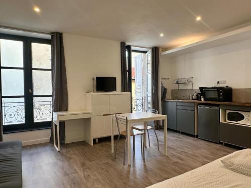 Cette chambre comprend une cuisine et une table avec table. dans l'établissement Dolaizon 2 - Studio Meublé 28 M2, au Puy-en-Velay