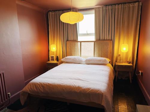 a bedroom with a white bed with a window and a lamp at Margate Manor - Rooms by the Sea in Margate