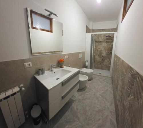 a bathroom with a sink and a toilet and a mirror at Elisabeth House in Giardini Naxos