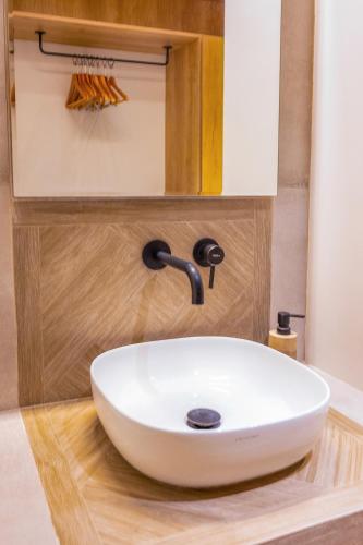 a white sink in a bathroom with a mirror at Princess Hotel in Lassi