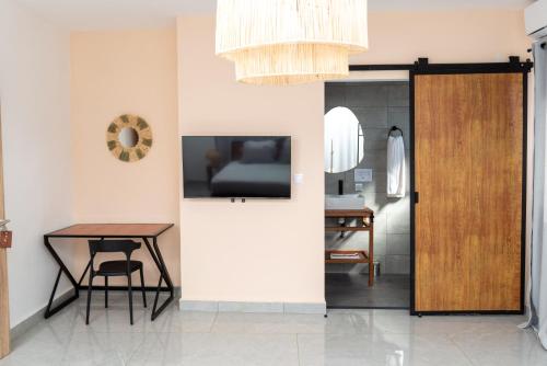 a dining room with a table and a wooden door at Hotel Naka in Diego Suarez