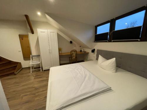 a bedroom with a large white bed and a staircase at Avenue Das Gästehaus in Chemnitz