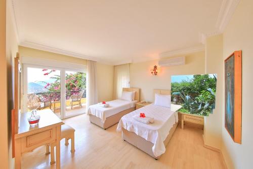 Una habitación de hotel con dos camas y balcón. en Villa Noyan, en Kas